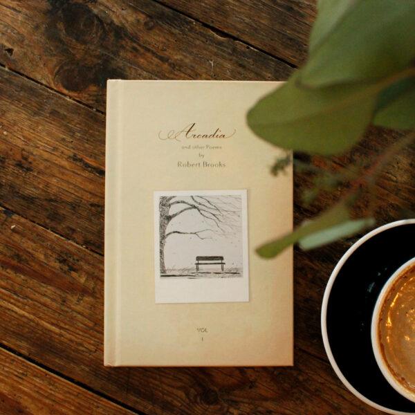 Hardcover poetry book by Robert Brooks styled in a cozy cafe setting, perfect for literary enthusiasts enjoying coffee and inspirational reading moments.